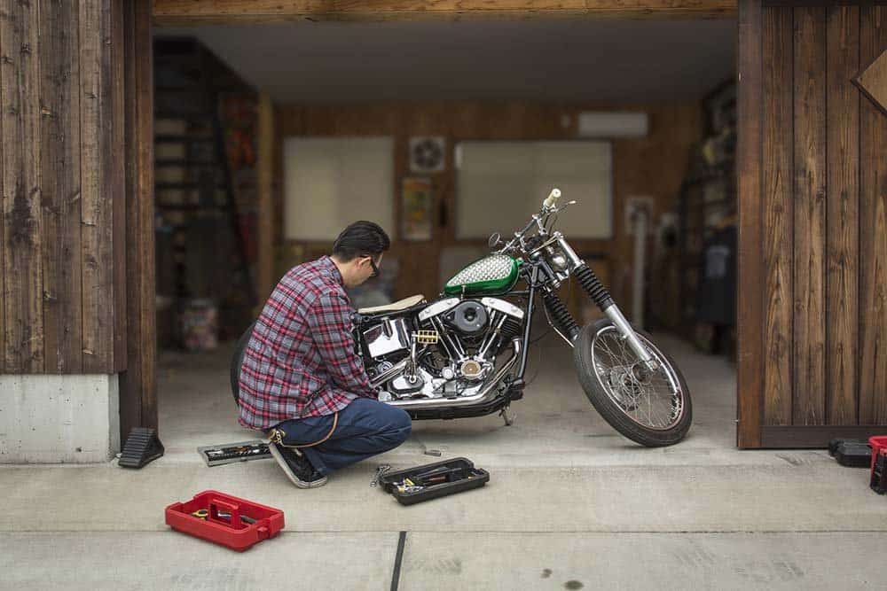 A man repairing his motorcycle in his garage