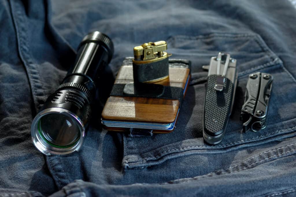 edc - everday carry items include flashlight, lighter, wallet, knives, multitool.