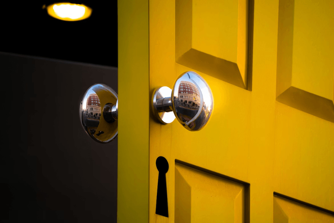 Close-up of a yellow door with two security