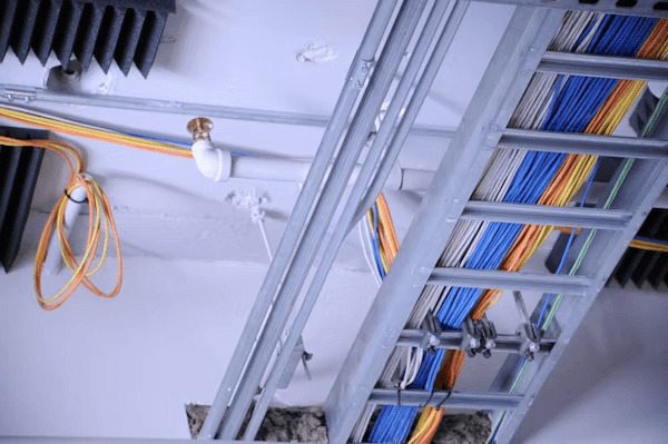 Messy electrical wires hanging on a wall