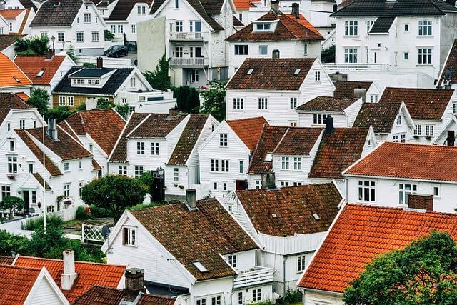Group of white houses with red roofs, representing