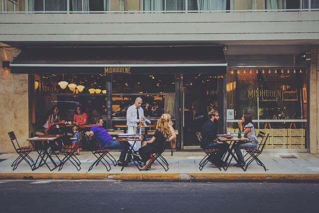 People dining at tables outside a restaurant