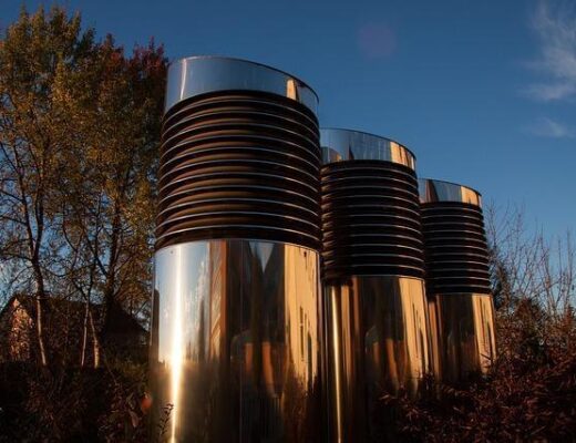 Stacked metal containers on a green field, possibly related