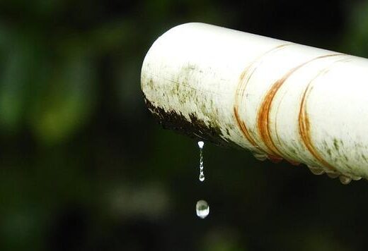 White pipe with a hanging water drop indicating