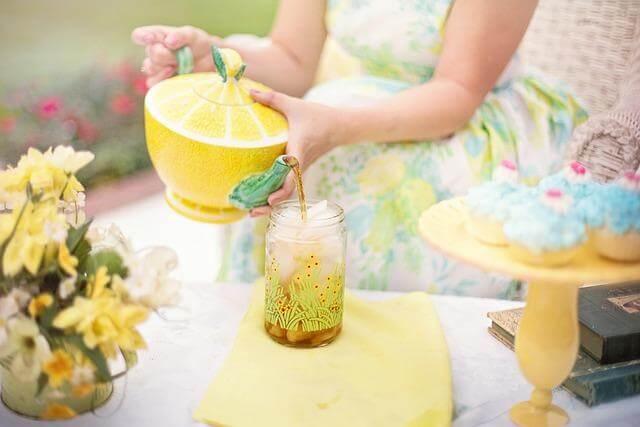 7 New Tea Traditions To Try on International Tea Day 3 Woman holding a lemon in a jar, likely for