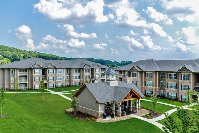 Is Buying an Apartment Actually Better Than Renting? 1 Apartment buildings in a green field, representing housing