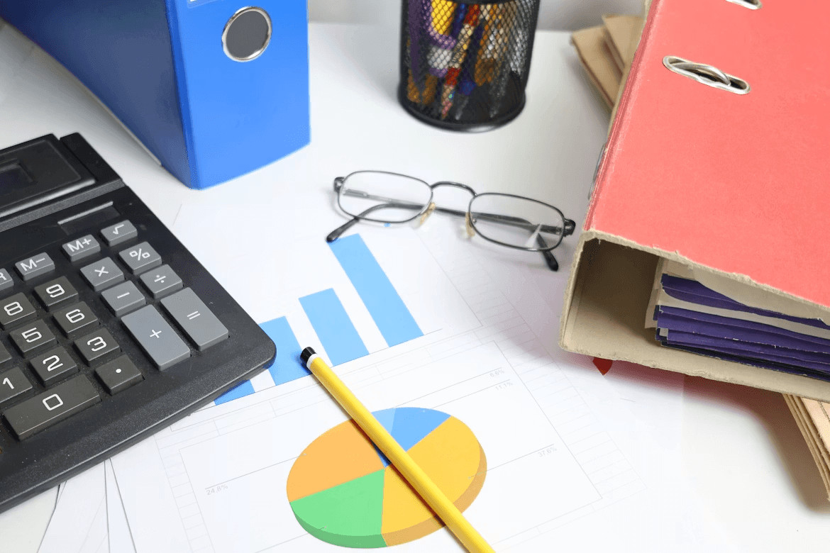 Creative Ways to Build a Down Payment for Your First Home 1 Desk with calculator, pen, glasses, and