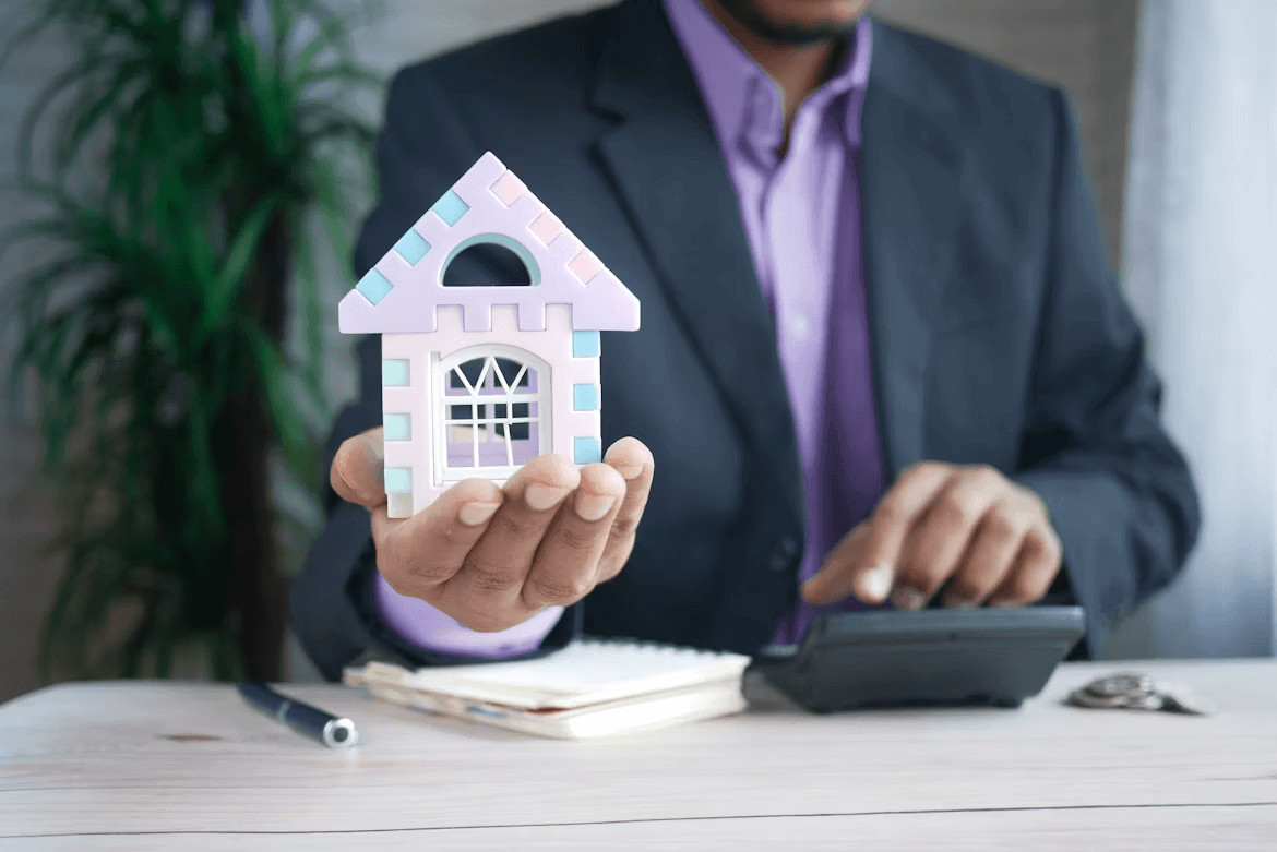 Creative Ways to Build a Down Payment for Your First Home 2 Man in suit holding toy house, symbolizing first