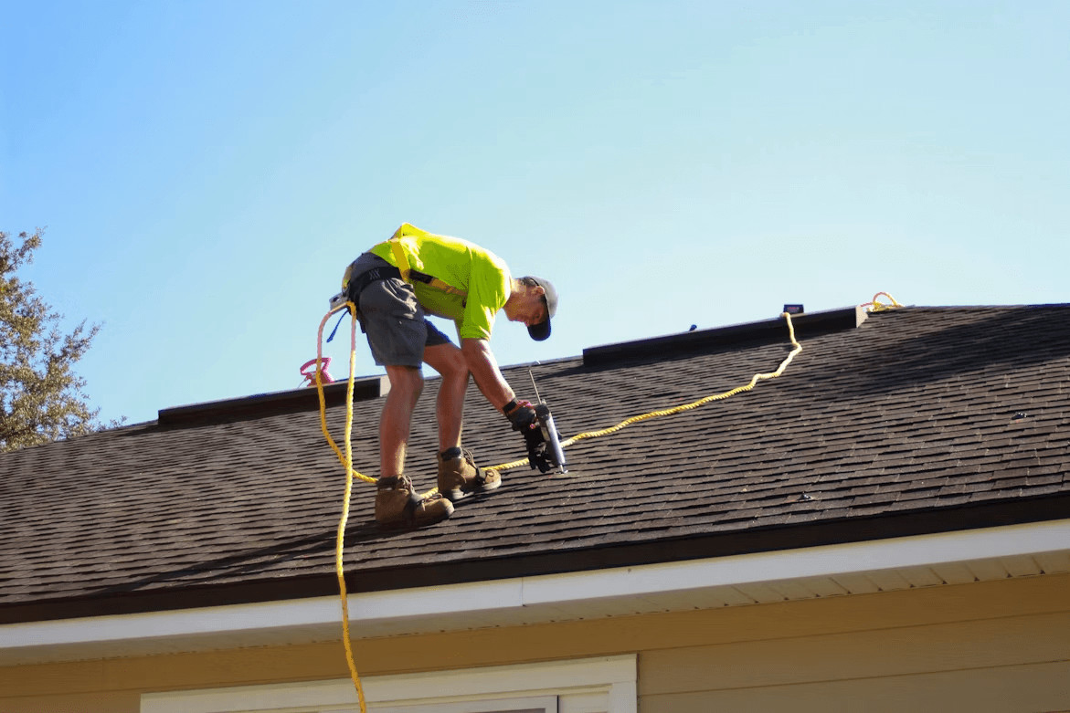 Man repairs roof with power drill to