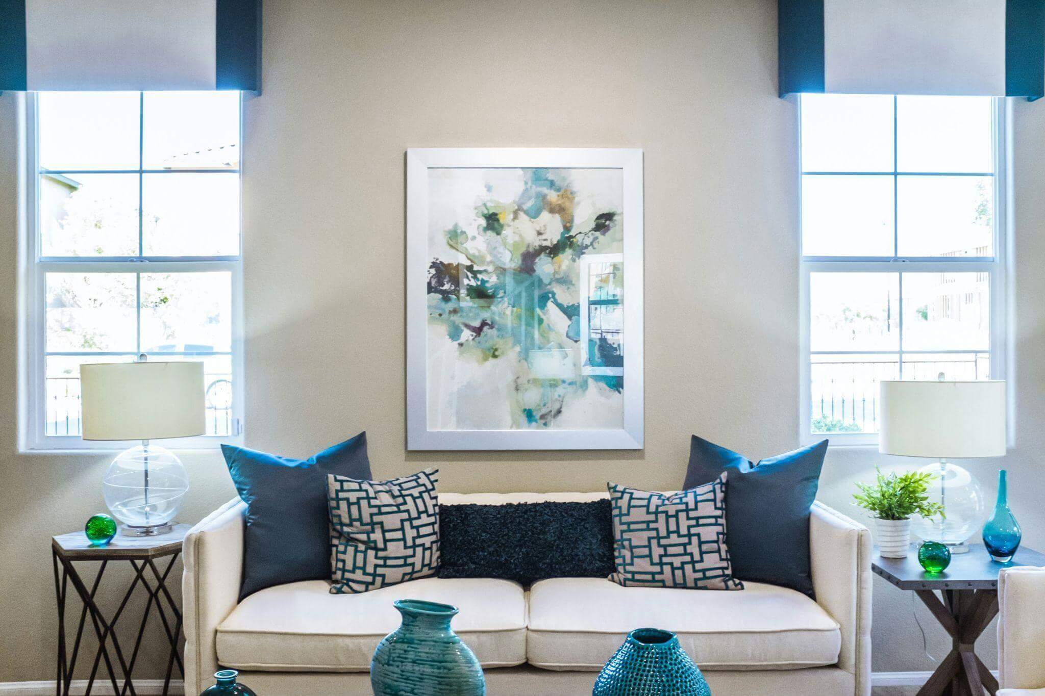 A furnished living room with a painting on the wall