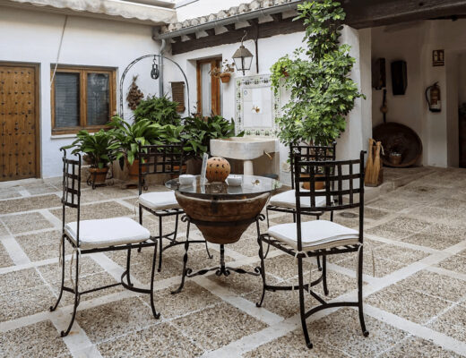 A patio with table, chairs, and potted plants