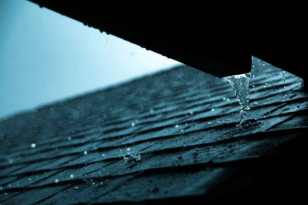 Close-up of a roof showing water overflowing from