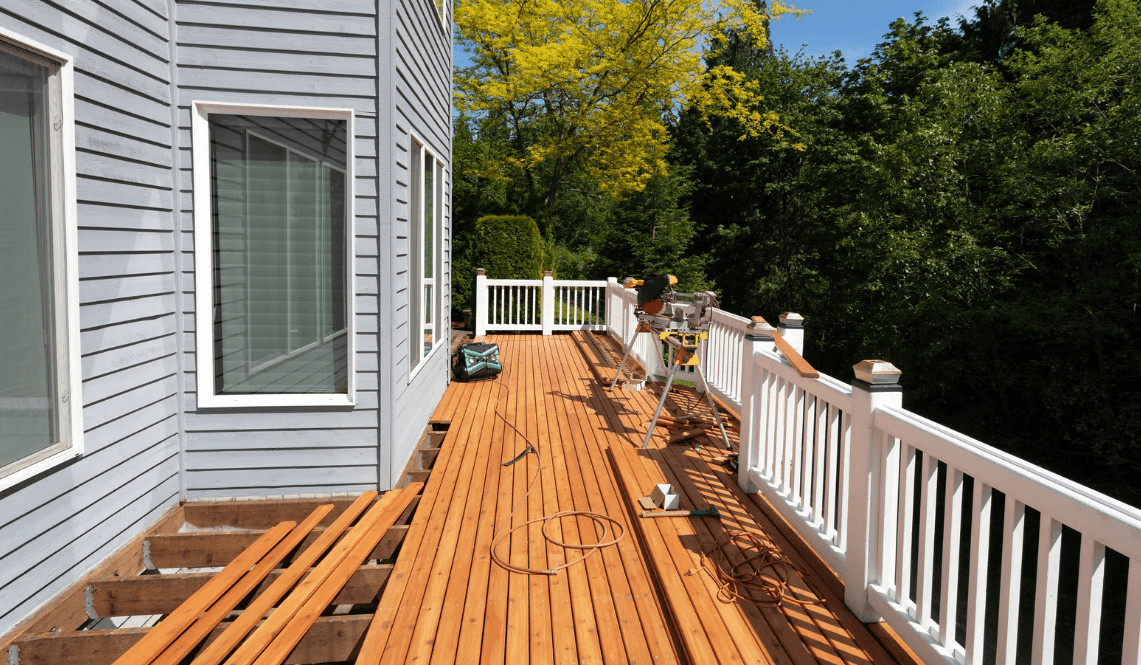 Durable wooden deck with white railing and bright