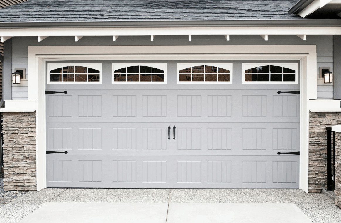 Gray garage door with windows on a house