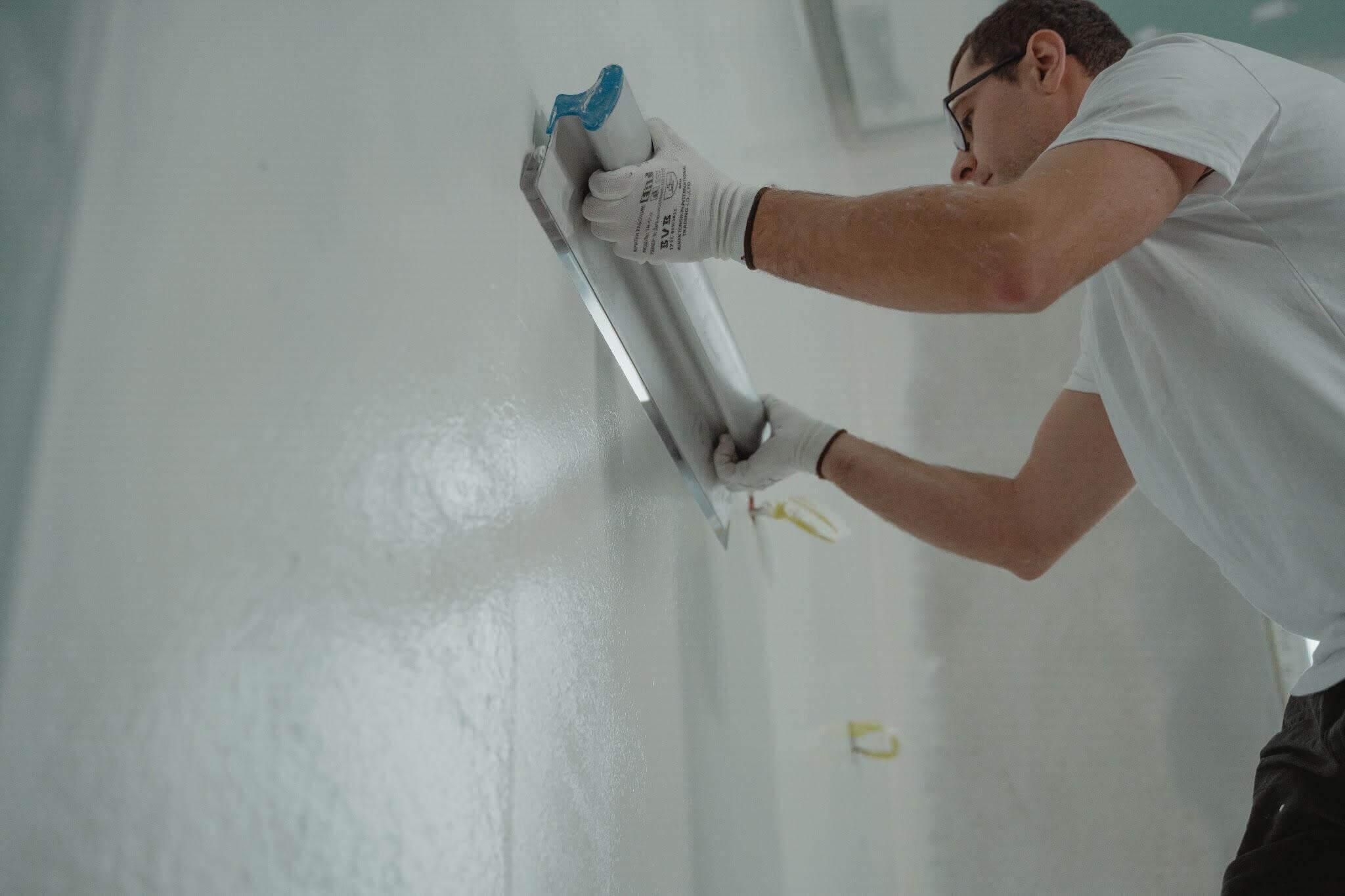 Choosing the Right Wall Finishes for Renovation 1 Man applying wall finish with paint roller