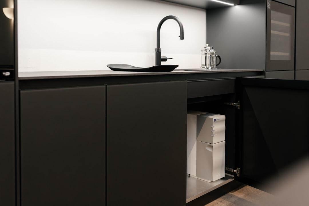 Modern kitchen with sink and black countertop, ready for