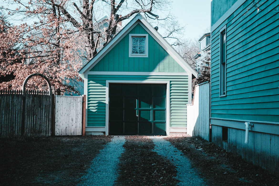 Common Mistakes To Avoid When You Schedule Garage Door Spring Repair 1 Small green building with a black garage-