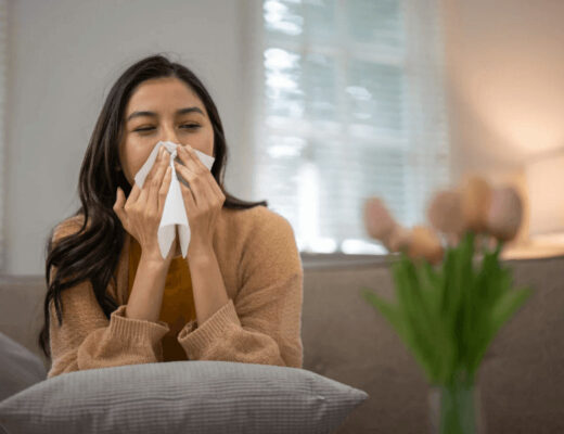 Allergy Hotspots In Family Homes: Where Irritants Hide And How To Reduce Them 5 Woman on couch blowing her nose, highlighting