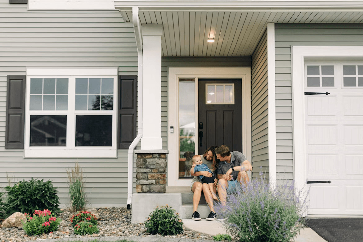 Couple sitting in front of a house