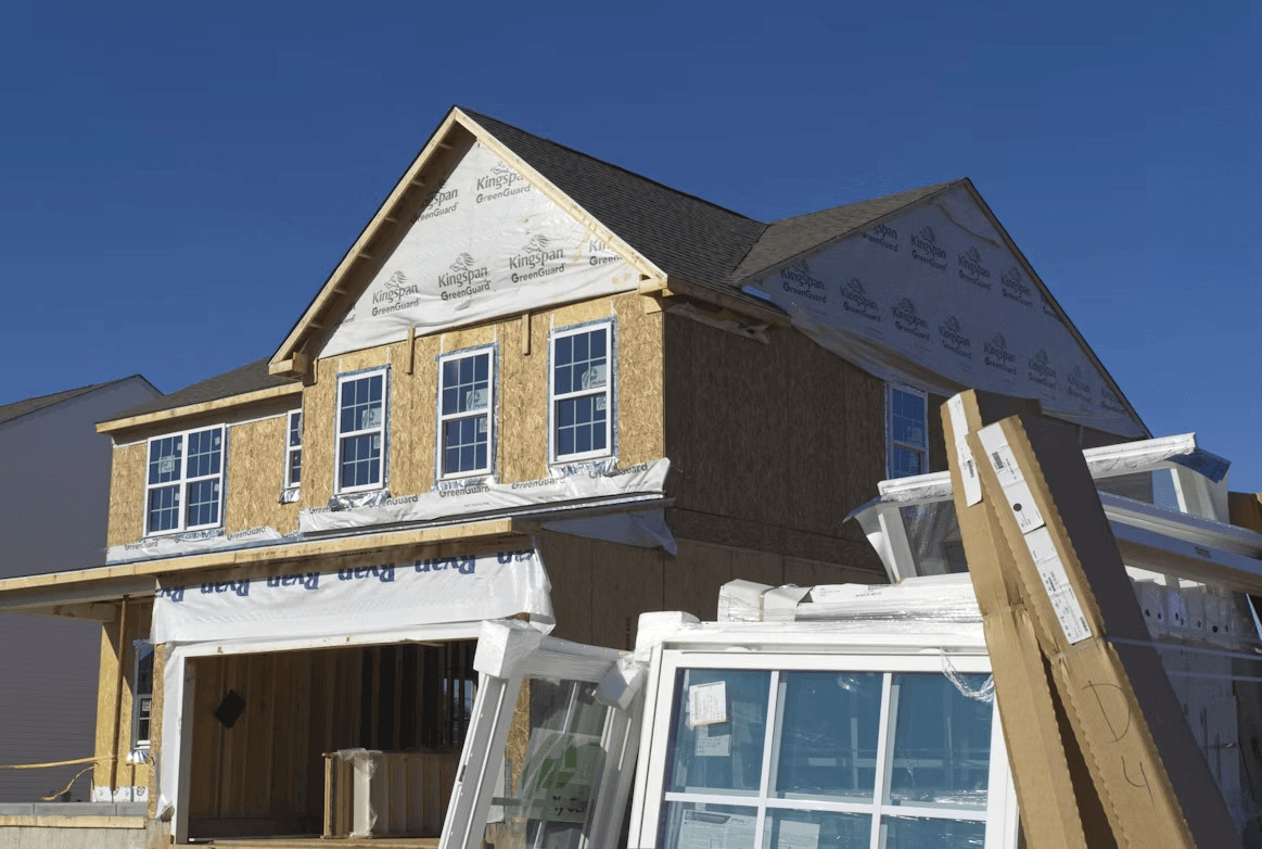 Custom home under construction with incomplete roof