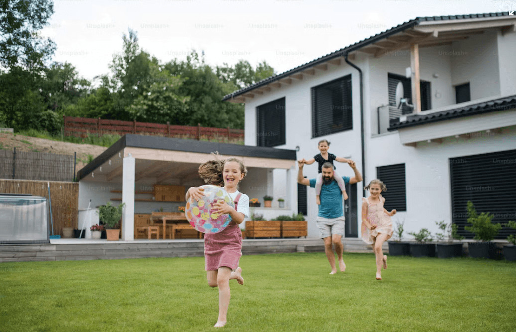 Kids happily playing frisbee in a maintained home yard