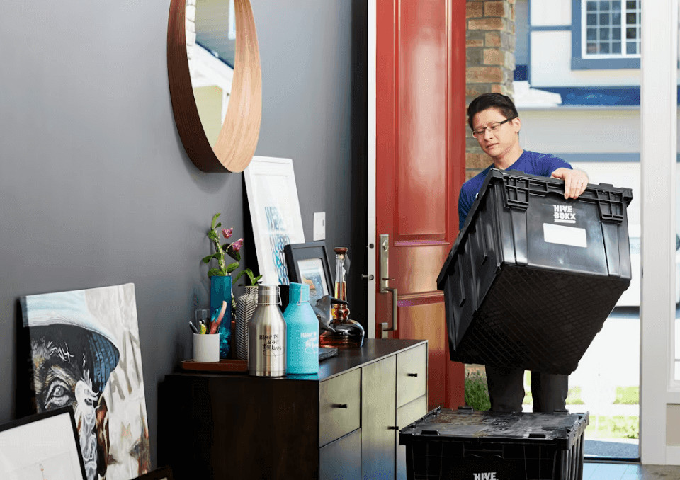 Tips That Can Make a Home Move A Lot Easier 1 Man carrying a large moving box in a room