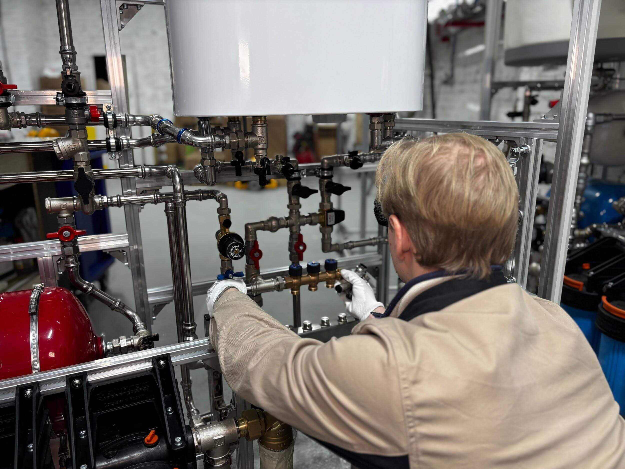 Man in tan jacket installing a water heater
