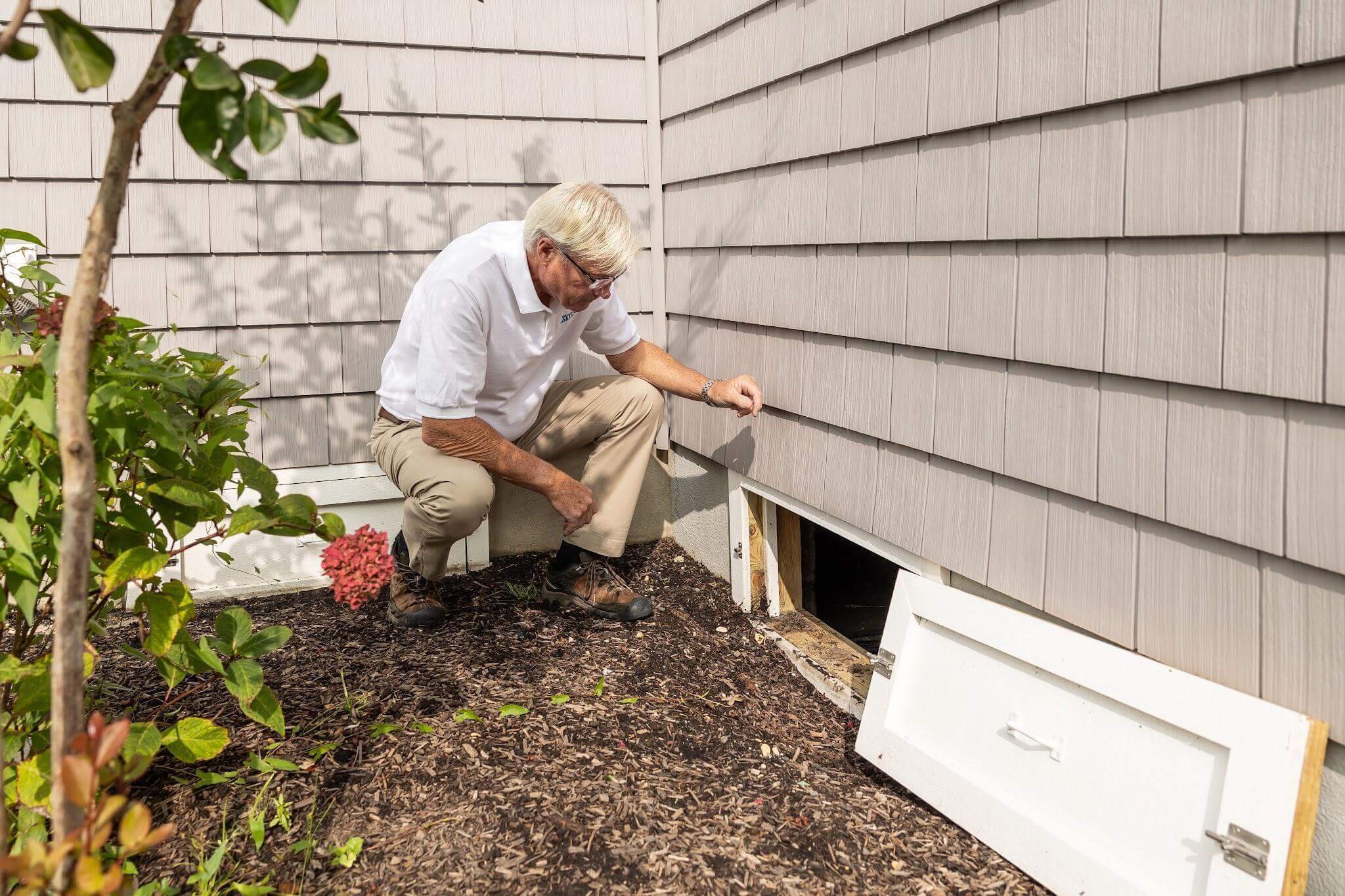 Man repairing a gutter on a house