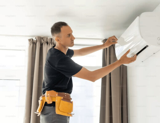 Man repairing a wall-mounted AC unit in