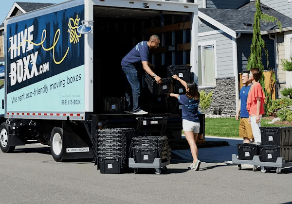 Man unloading a box from a moving truck in