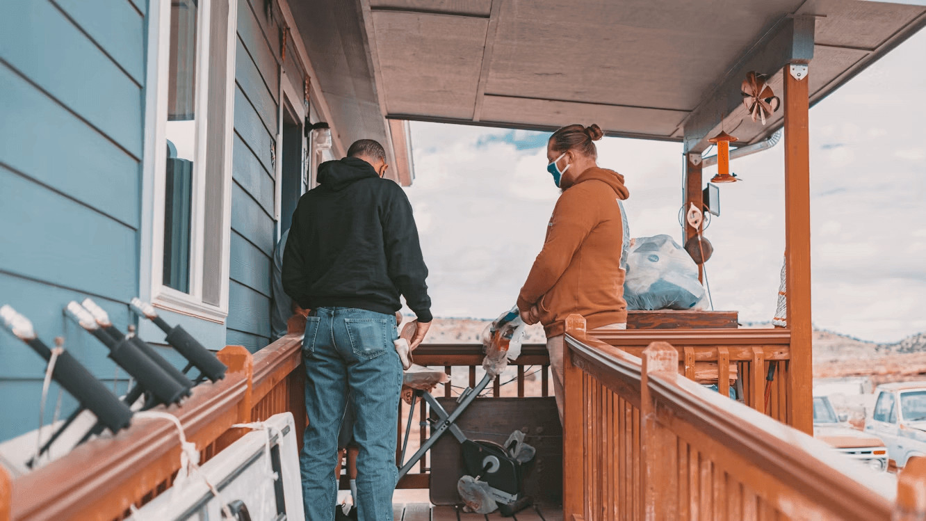 Two men standing on a wooden porch of a