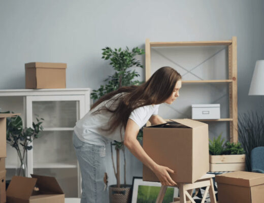 Woman moving moving boxes in a living
