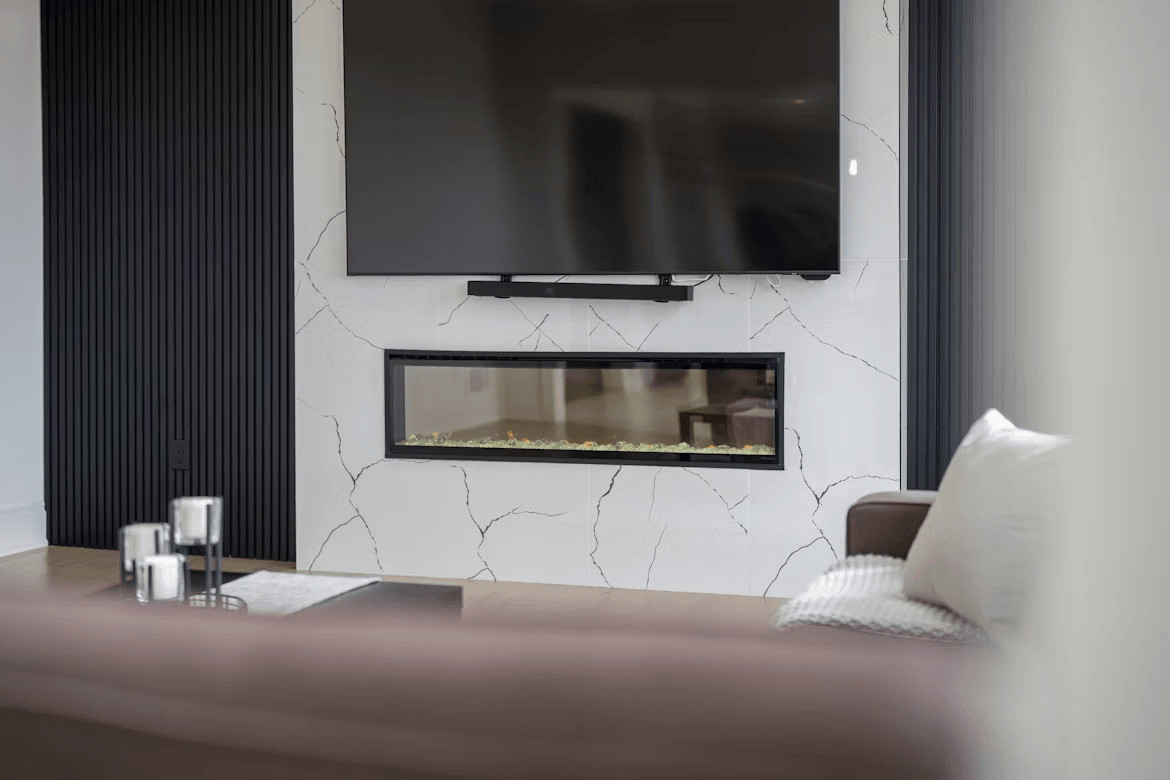 Flat screen TV mounted above a fireplace in a modern