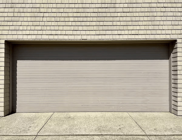 Garage Door Installation, Repairs, and Maintenance Every Homeowner Should Know 1 Garage door on a brick building