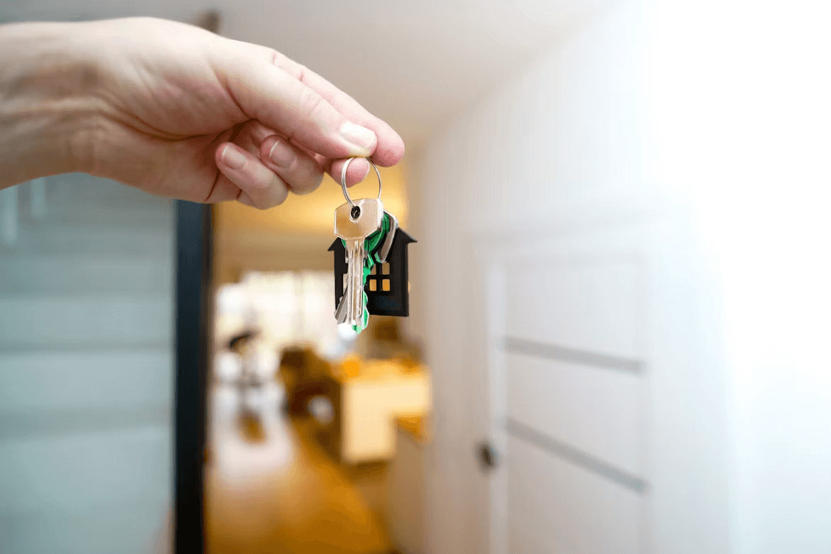 Hand holding a house-shaped key chain,