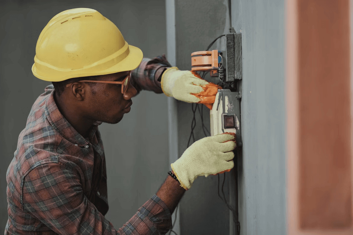 Man in hard hat and gloves repairing a wall