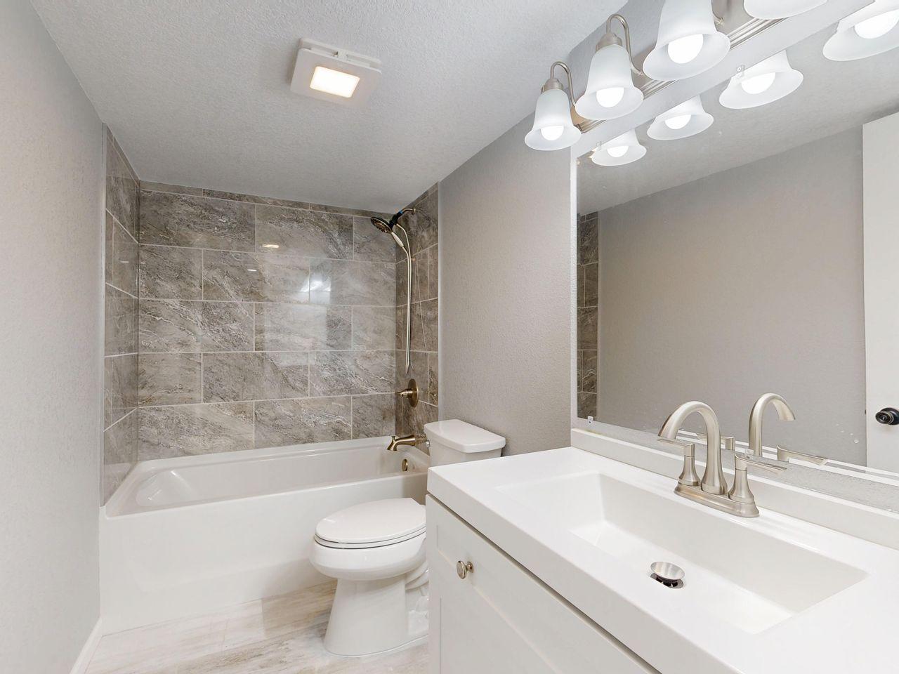 modern bathroom with sink, toilet, and bathtub