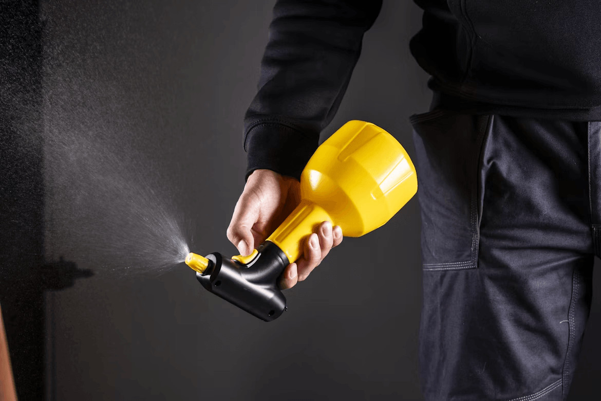 Person using a yellow sprayer for pest control