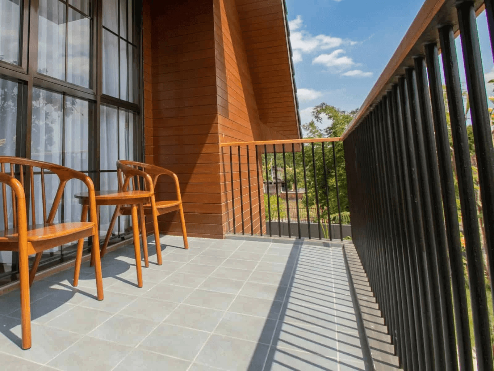 Two wooden chairs on a balcony overlooking a building