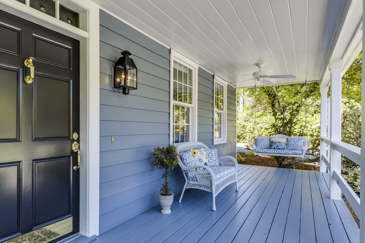 A porch with two chairs and a table,