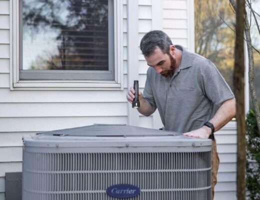 HVAC technician inspecting an outdoor air conditioner unit