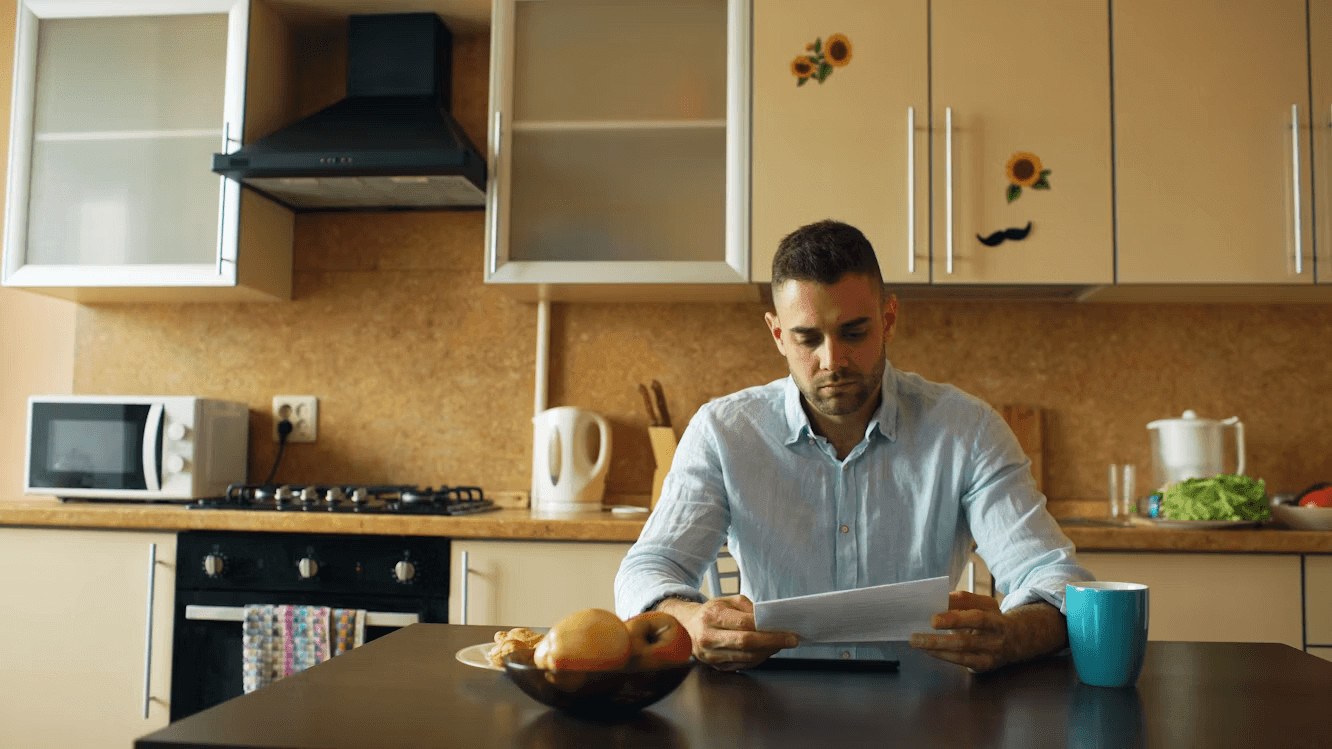 Man examining a document, possibly an energy bill or