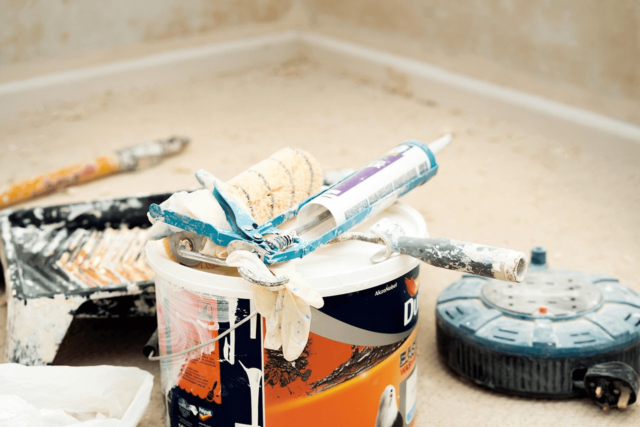 Toothpaste can and toothbrush on floor amidst renovation