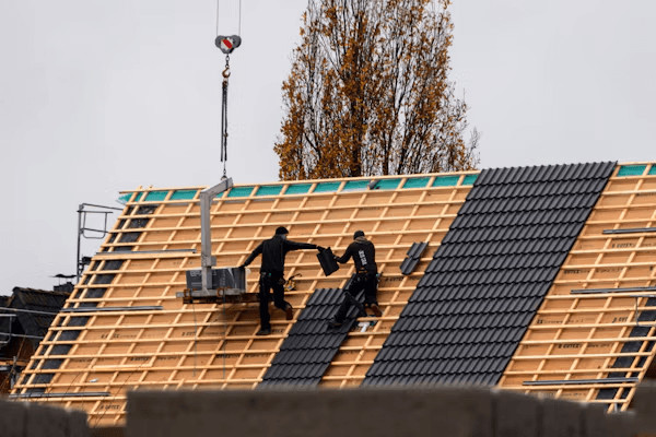 How to Decide Between Repairing or Replacing a Leaking Roof Before Winter 1 Two men repairing a roof