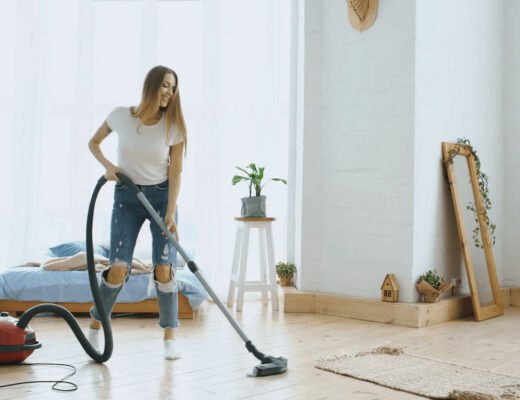 How to Reduce Household Dust and Improve Indoor Air Quality 1 Woman vacuuming a bed to reduce household dust